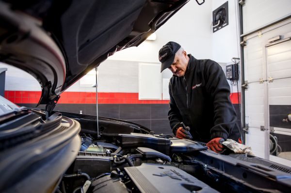 Diagnosta CarPoint sprawdza komorę silnika samochodu na stanowisku kontrolnym